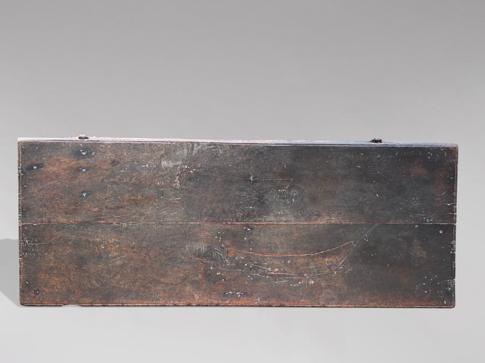 A seventeenth-century dark oak joined coffer with four carved panelled sections, a carved top rail dated 1678, and carved initials IMS. View V