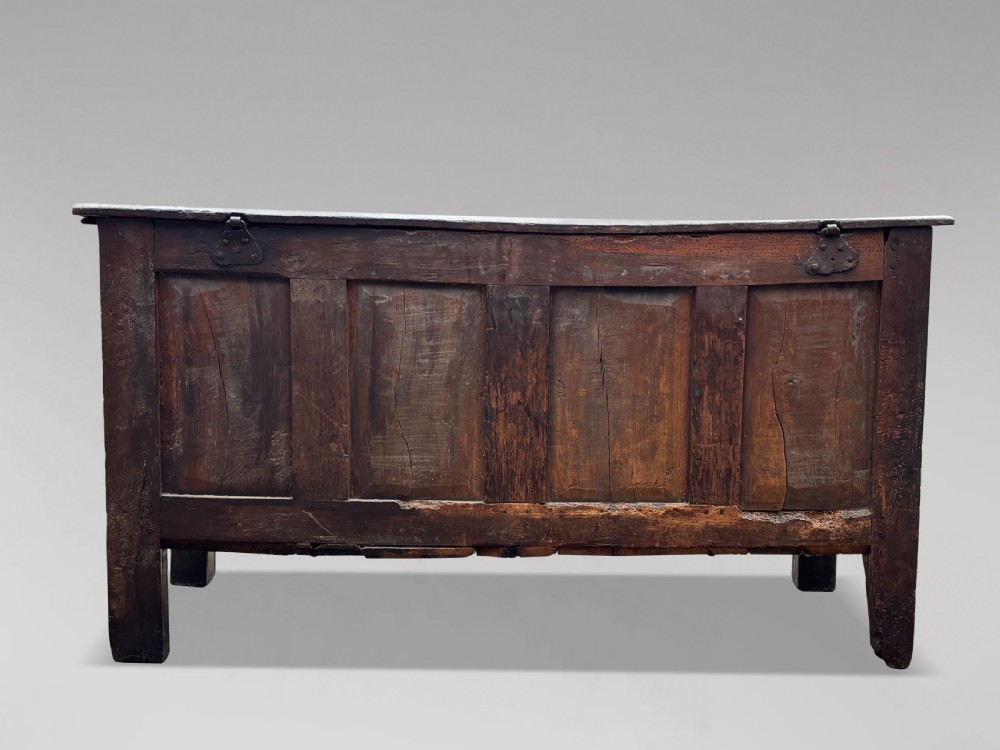 A seventeenth-century dark oak joined coffer with four carved panelled sections, a carved top rail dated 1678, and carved initials IMS. View VII