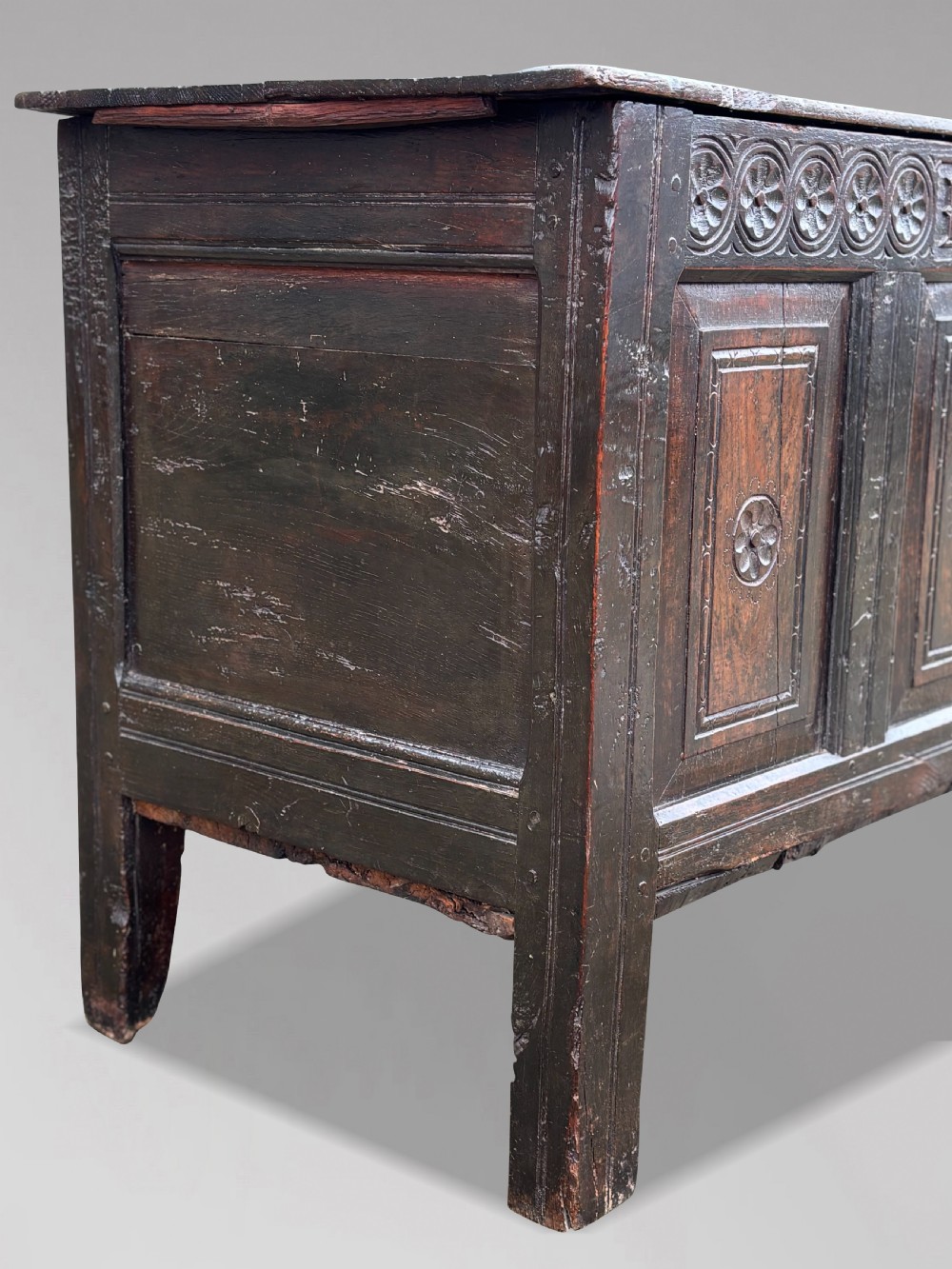 A seventeenth-century dark oak joined coffer with four carved panelled sections, a carved top rail dated 1678, and carved initials IMS. View XI
