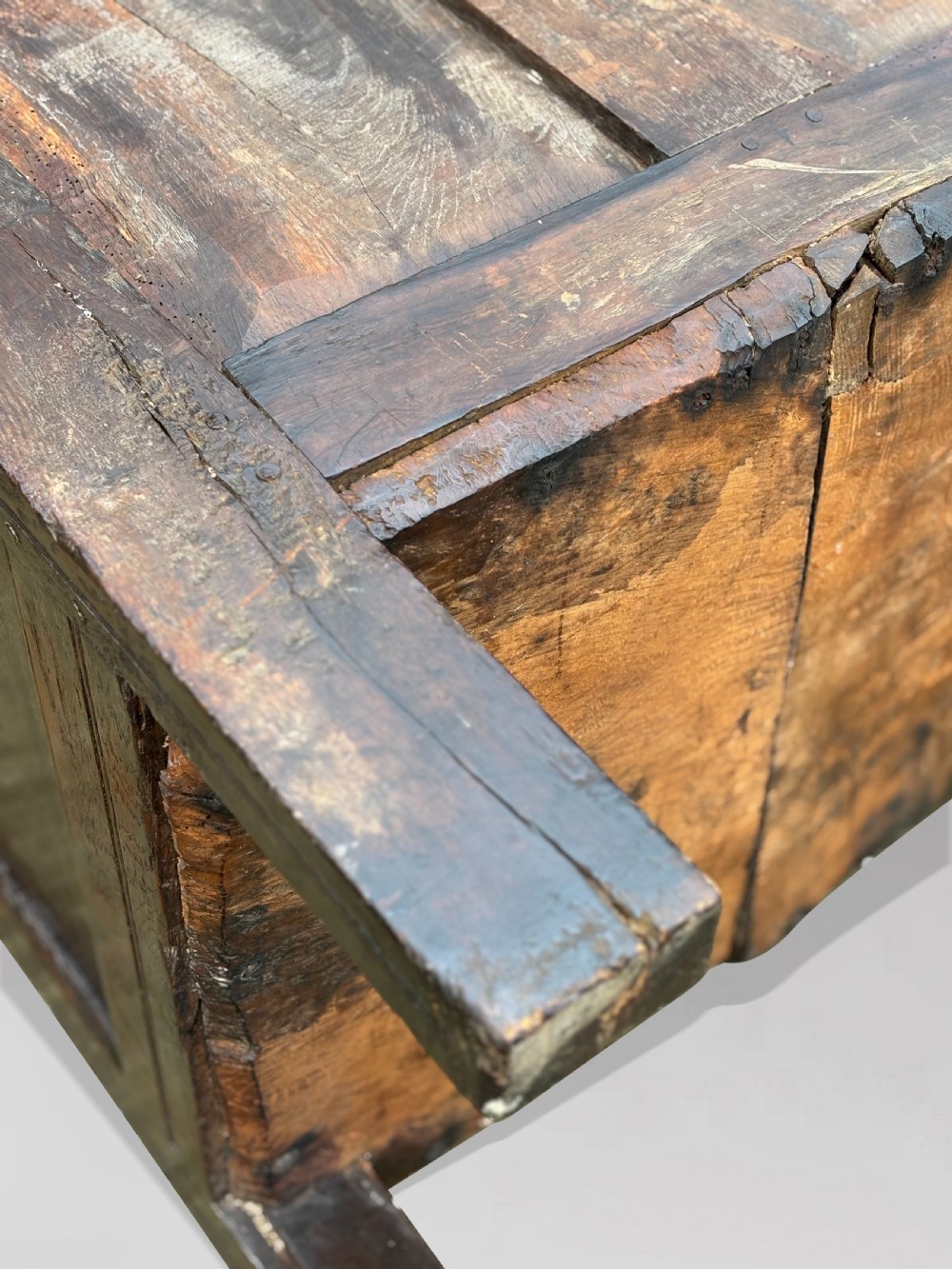 A seventeenth-century dark oak joined coffer with four carved panelled sections, a carved top rail dated 1678, and carved initials IMS. View XII