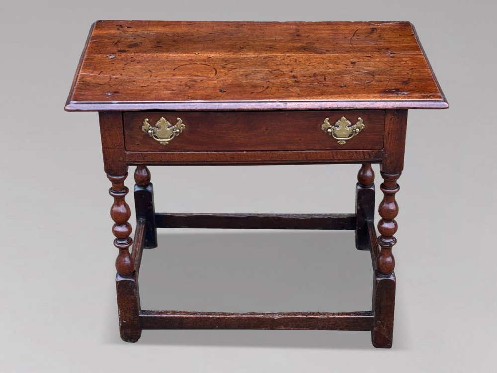 An early 18th-century George I period walnut lowboy side table featuring a single drawer with brass handles, turned legs, and a low box stretcher. View II
