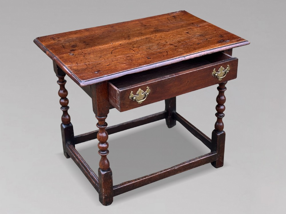 An early 18th-century George I period walnut lowboy side table featuring a single drawer with brass handles, turned legs, and a low box stretcher. View V