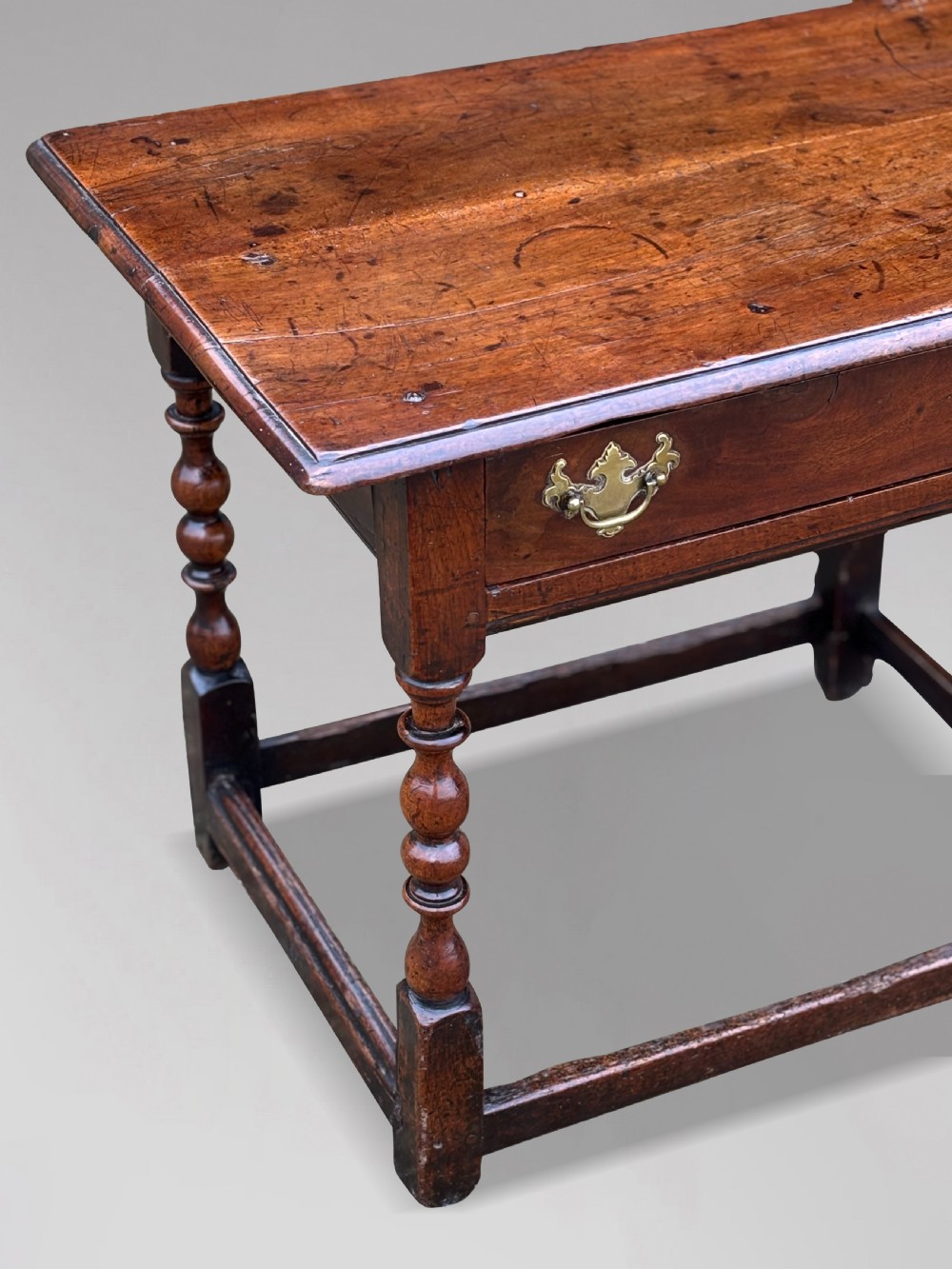 An early 18th-century George I period walnut lowboy side table featuring a single drawer with brass handles, turned legs, and a low box stretcher. View VI