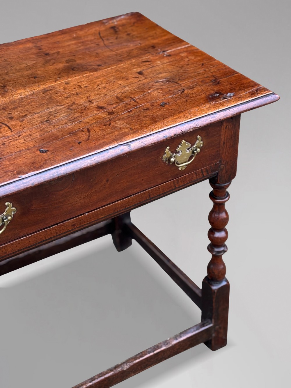 An early 18th-century George I period walnut lowboy side table featuring a single drawer with brass handles, turned legs, and a low box stretcher. View VII