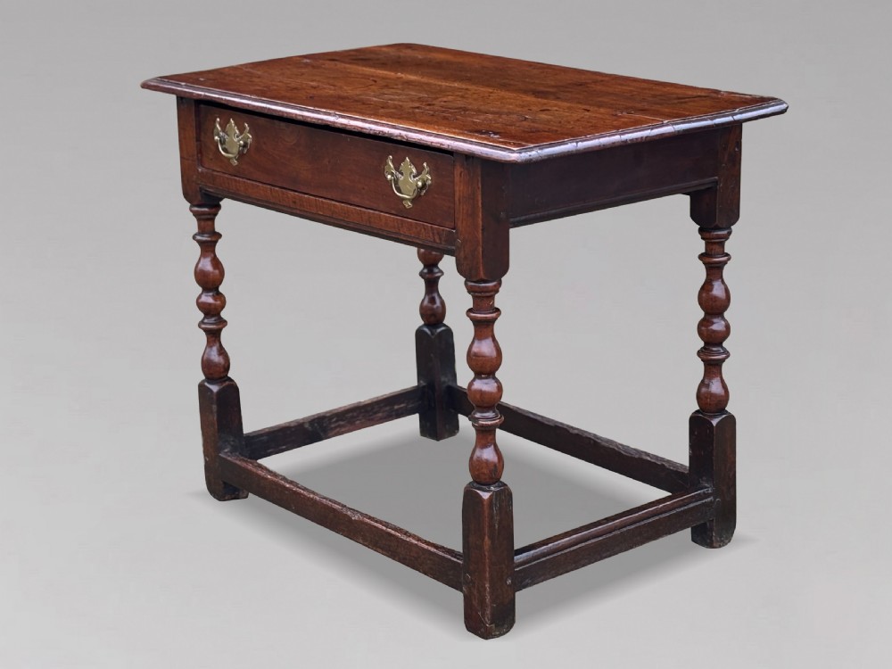 An early 18th-century George I period walnut lowboy side table featuring a single drawer with brass handles, turned legs, and a low box stretcher. View IX