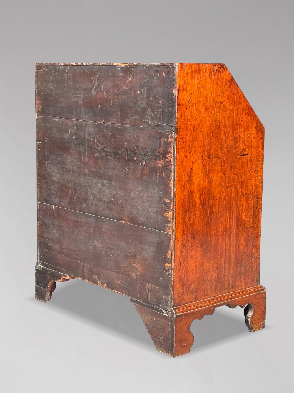 An 18th-century George III mahogany slant-front bureau featuring four graduated drawers with brass swan-neck handles and shaped bracket feet. View III