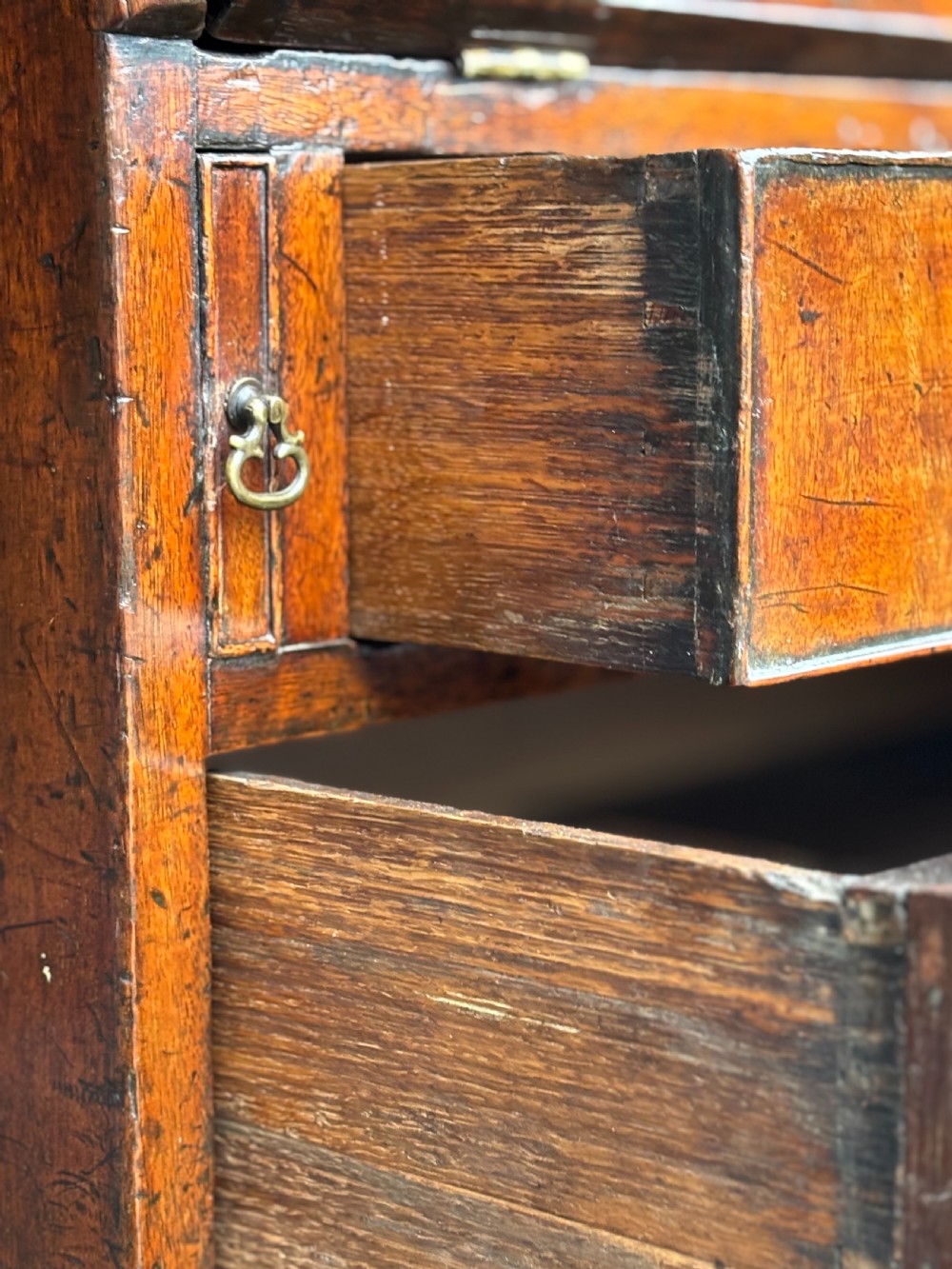 An 18th-century George III mahogany slant-front bureau featuring four graduated drawers with brass swan-neck handles and shaped bracket feet. View IV