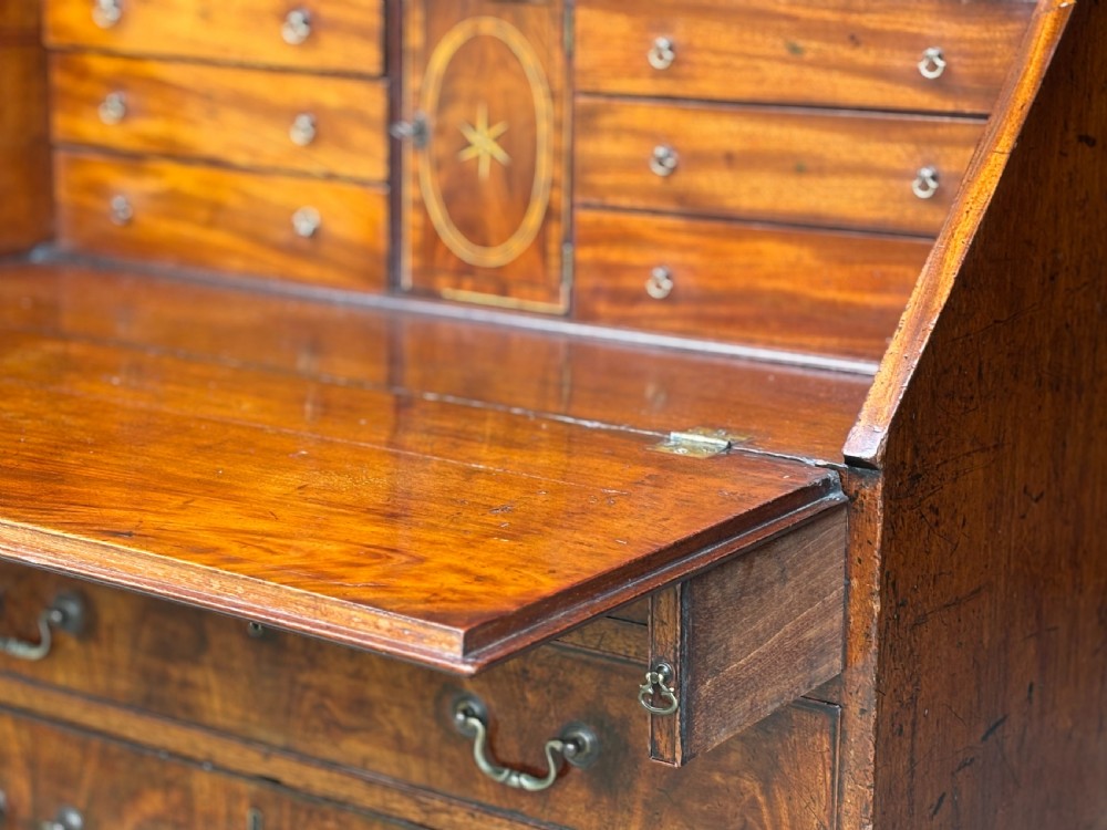 An 18th-century George III mahogany slant-front bureau featuring four graduated drawers with brass swan-neck handles and shaped bracket feet. View VIII