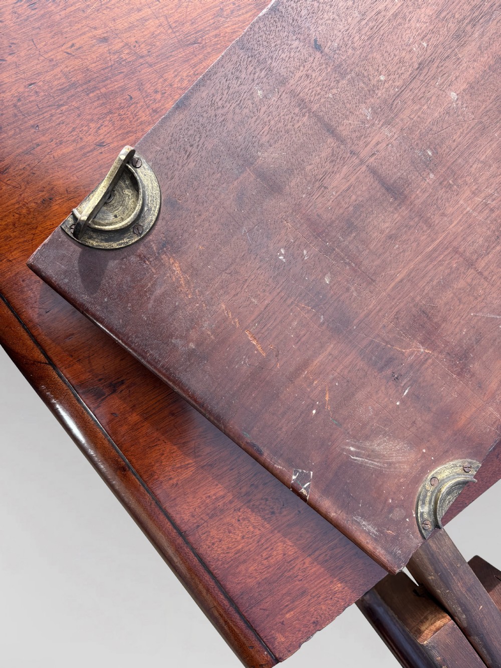 A 19th-century mahogany extending dining table featuring a polished rectangular top with rounded corners, supported by four heavy turned legs on brass castors. View VII