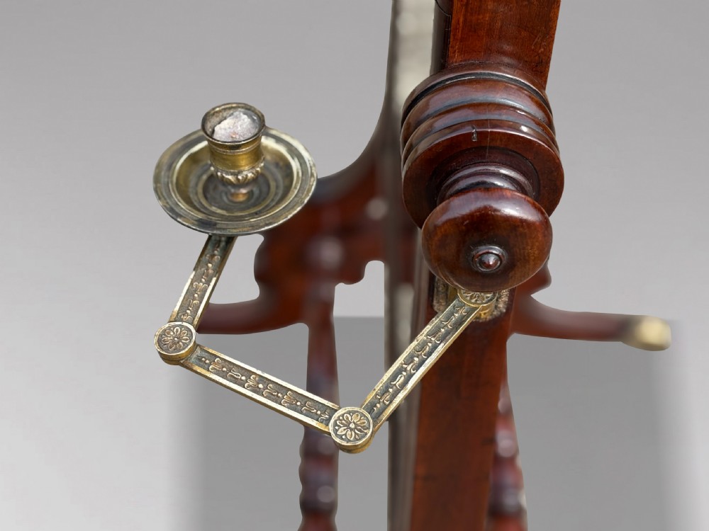 A 19th-century William IV mahogany cheval mirror featuring a rectangular swivel glass plate, dual brass candle sconces, turned stretchers, and splayed legs with brass claw feet on castors. View IV