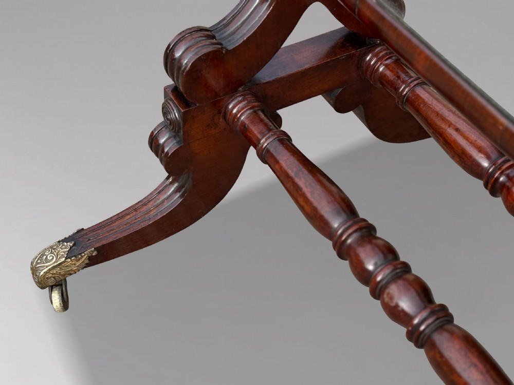 A 19th-century William IV mahogany cheval mirror featuring a rectangular swivel glass plate, dual brass candle sconces, turned stretchers, and splayed legs with brass claw feet on castors. View VIII