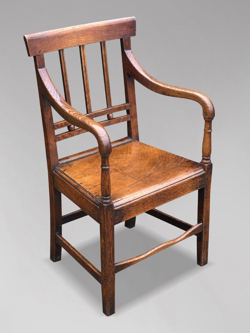 An 18th-century George III elm country armchair featuring a solid timber seat, curved arms, vertical back splats, and square legs. View II