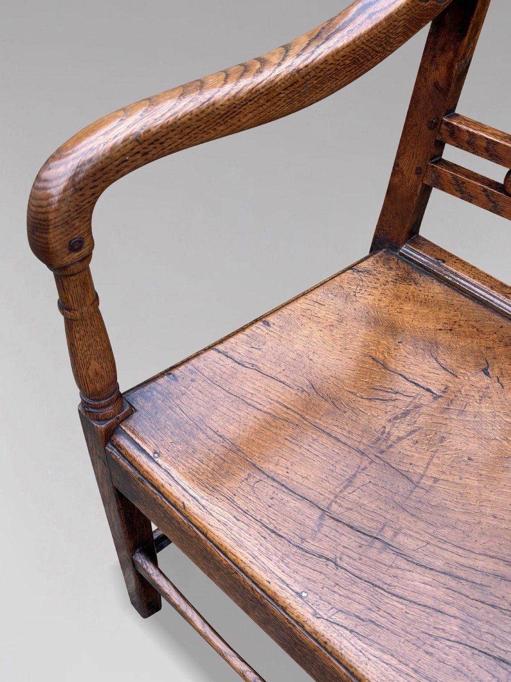 An 18th-century George III elm country armchair featuring a solid timber seat, curved arms, vertical back splats, and square legs. View V