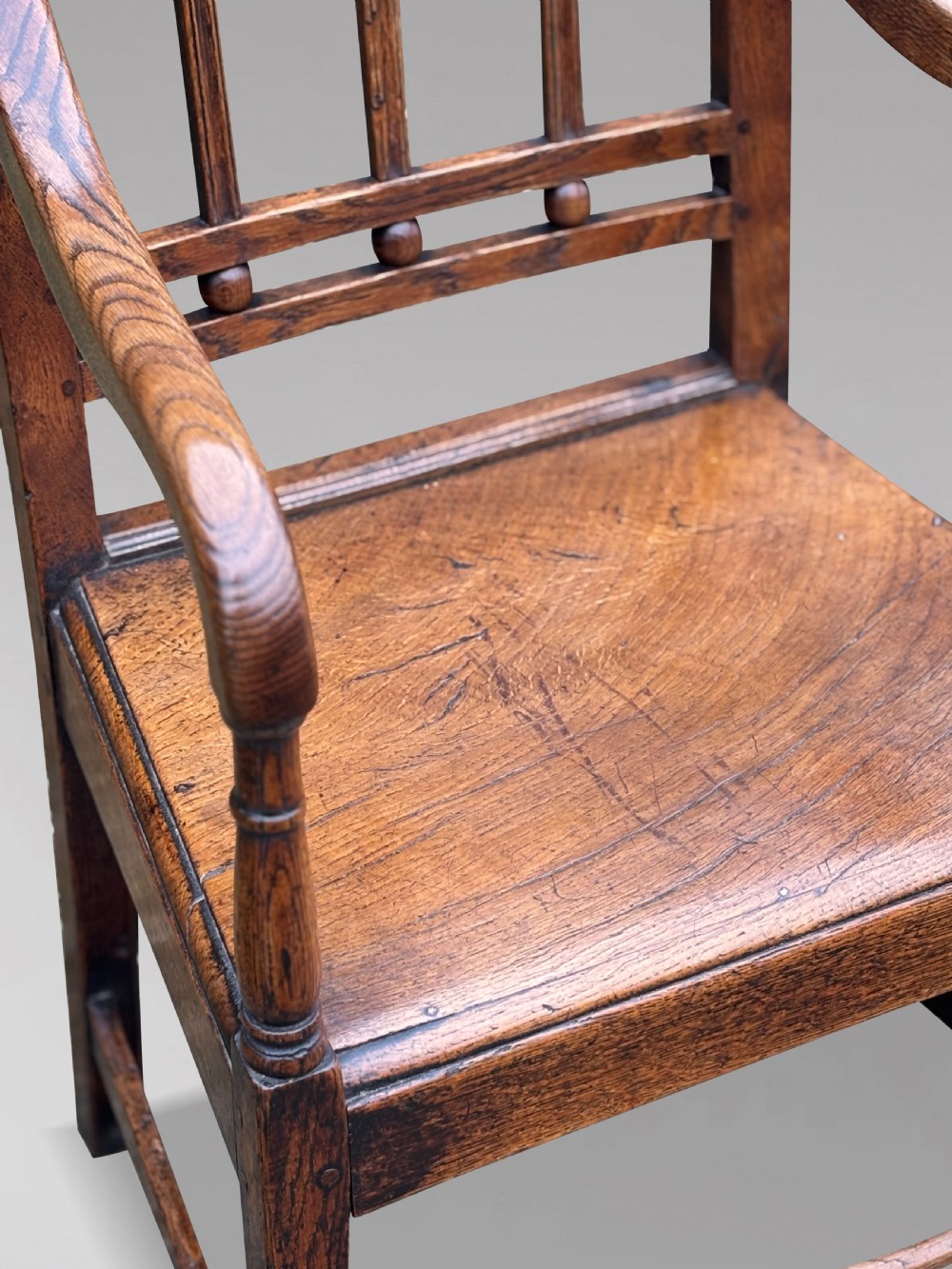 An 18th-century George III elm country armchair featuring a solid timber seat, curved arms, vertical back splats, and square legs. View VI
