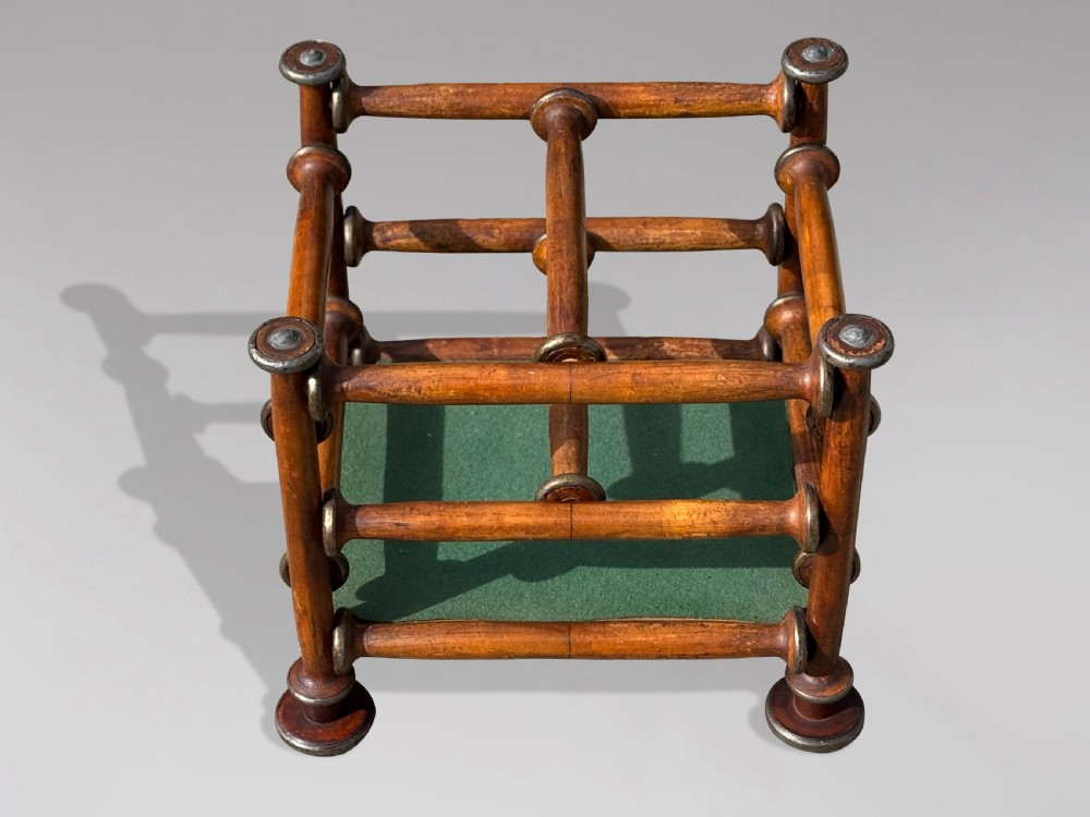 A late nineteenth-century walnut magazine rack with turned spindle framing, metal accents, central dividers, and a green fabric base. View II
