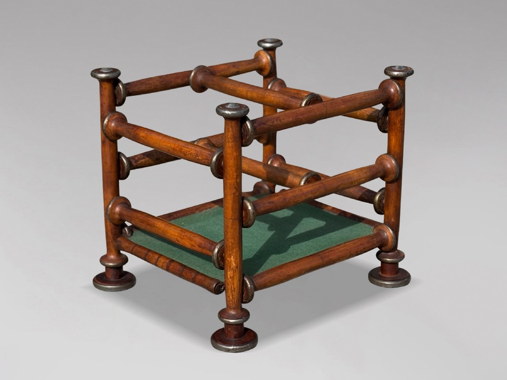 A late nineteenth-century walnut magazine rack with turned spindle framing, metal accents, central dividers, and a green fabric base. View III