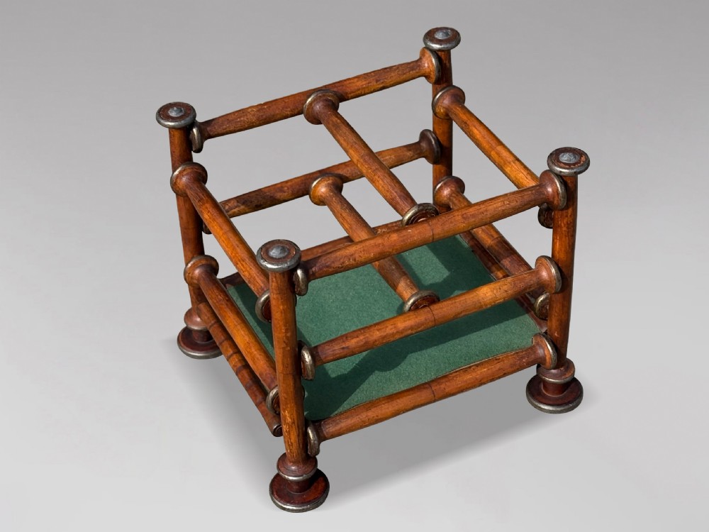 A late nineteenth-century walnut magazine rack with turned spindle framing, metal accents, central dividers, and a green fabric base. View IV