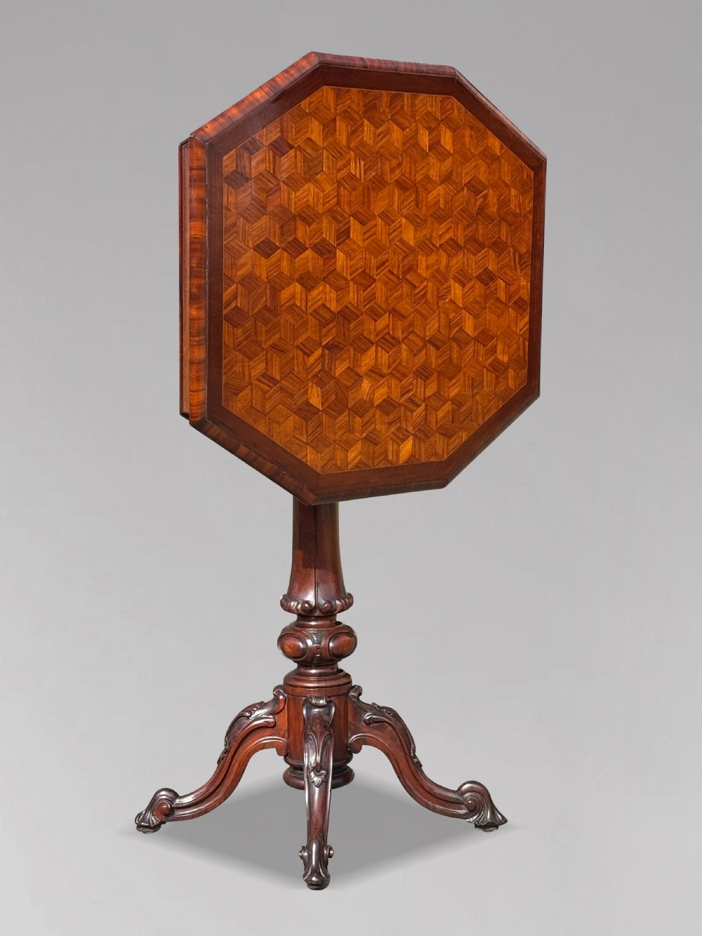 A Victorian walnut tilt-top table featuring an octagonal top decorated with a geometric parquetry pattern, supported by a carved pedestal and tripod legs. View III