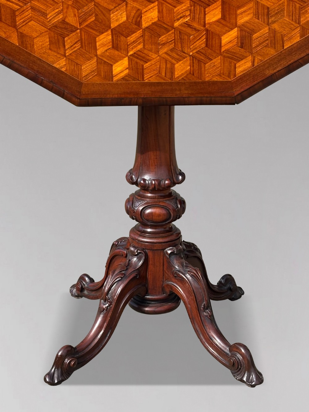 A Victorian walnut tilt-top table featuring an octagonal top decorated with a geometric parquetry pattern, supported by a carved pedestal and tripod legs. View IV