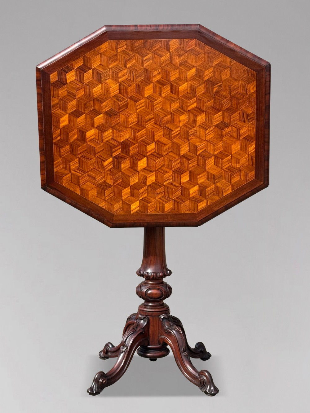 A Victorian walnut tilt-top table featuring an octagonal top decorated with a geometric parquetry pattern, supported by a carved pedestal and tripod legs. View V