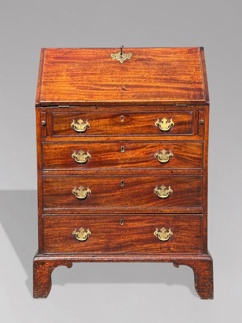 An 18th-century George III mahogany bureau featuring an open sloping slant front revealing small drawers and pigeonholes above four long drawers on bracket feet. View II