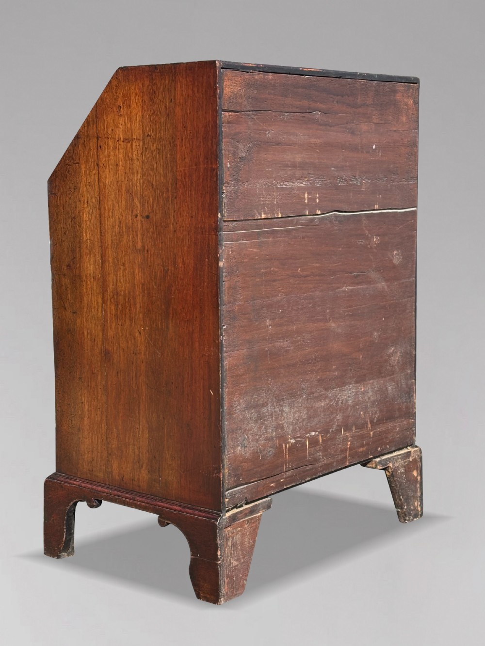 An 18th-century George III mahogany bureau featuring an open sloping slant front revealing small drawers and pigeonholes above four long drawers on bracket feet. View V