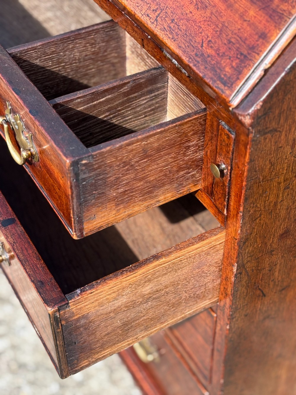 An 18th-century George III mahogany bureau featuring an open sloping slant front revealing small drawers and pigeonholes above four long drawers on bracket feet. View VI