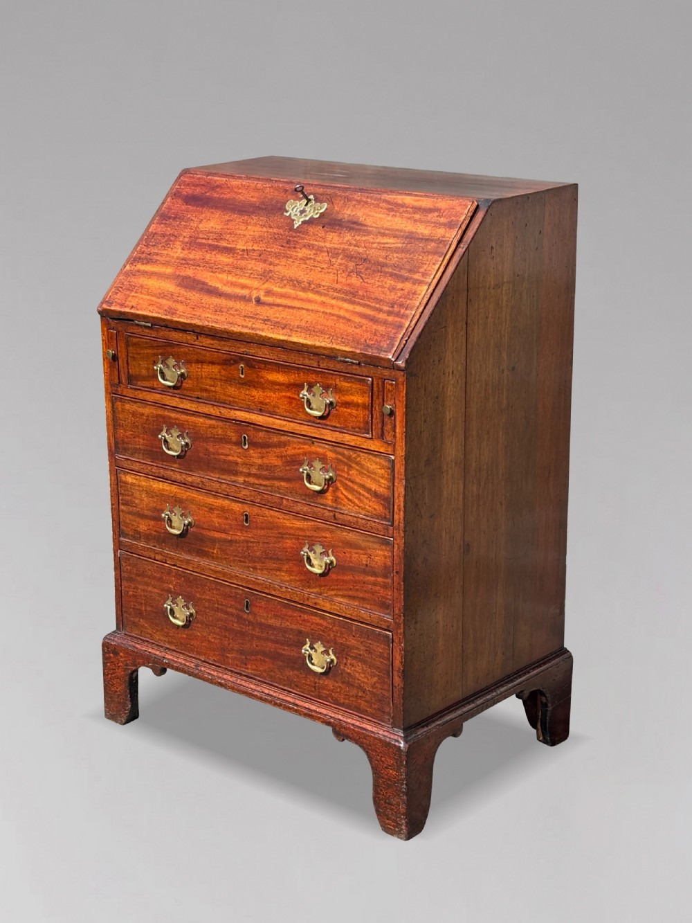 An 18th-century George III mahogany bureau featuring an open sloping slant front revealing small drawers and pigeonholes above four long drawers on bracket feet. View VIII
