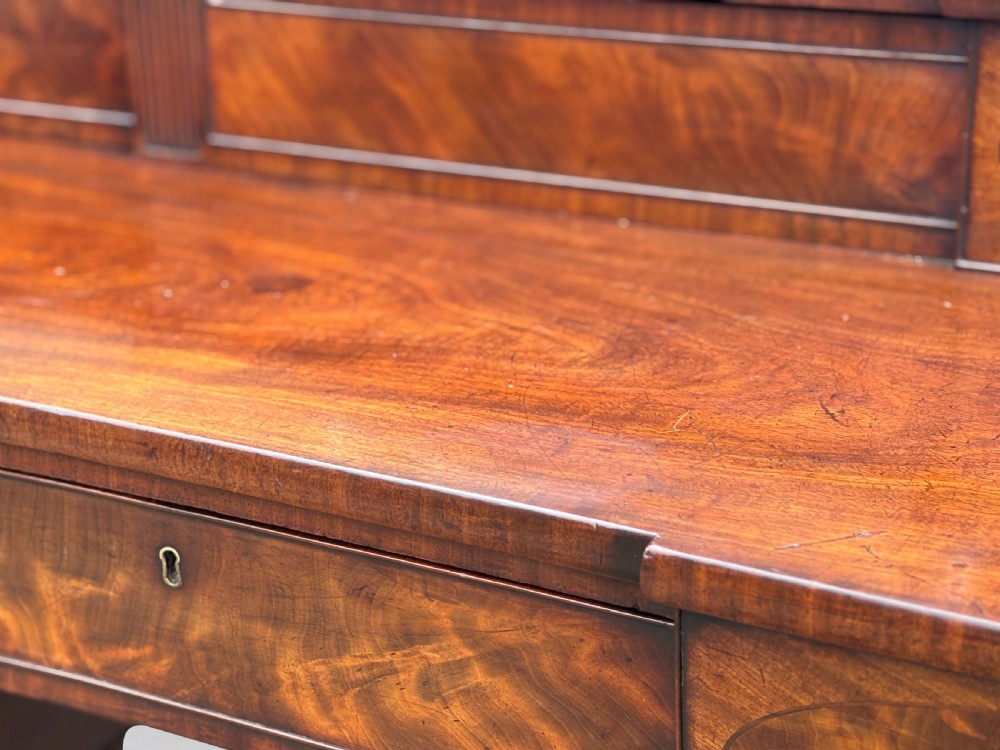 An 18th-century George III flame mahogany sideboard featuring a raised stage back, oval wood inlays, fluted side columns, and six turned reeded legs. View VIII