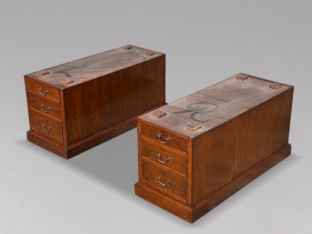 A late 19th-century oak partners desk featuring a green leather inset writing surface, twin pedestals with drawers and cupboards, and brass hardware. View IV