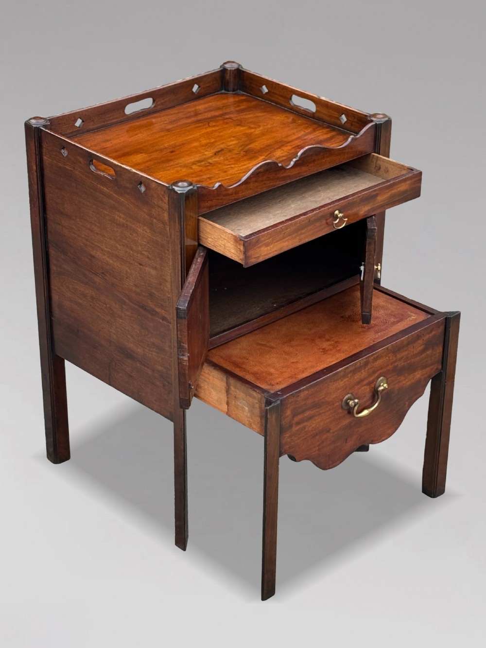A pair of 18th-century George III mahogany bedside cabinets featuring tray tops with pierced handles, twin cupboard doors, and pull-out lower drawers with brass drop handles. View VIII