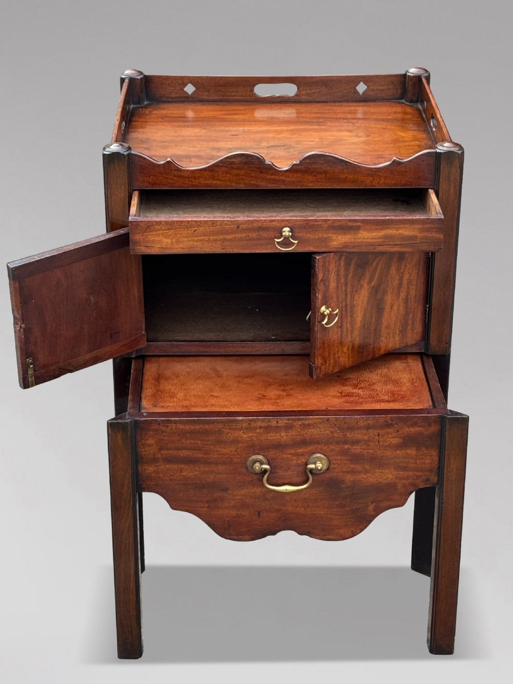 A pair of 18th-century George III mahogany bedside cabinets featuring tray tops with pierced handles, twin cupboard doors, and pull-out lower drawers with brass drop handles. View IX