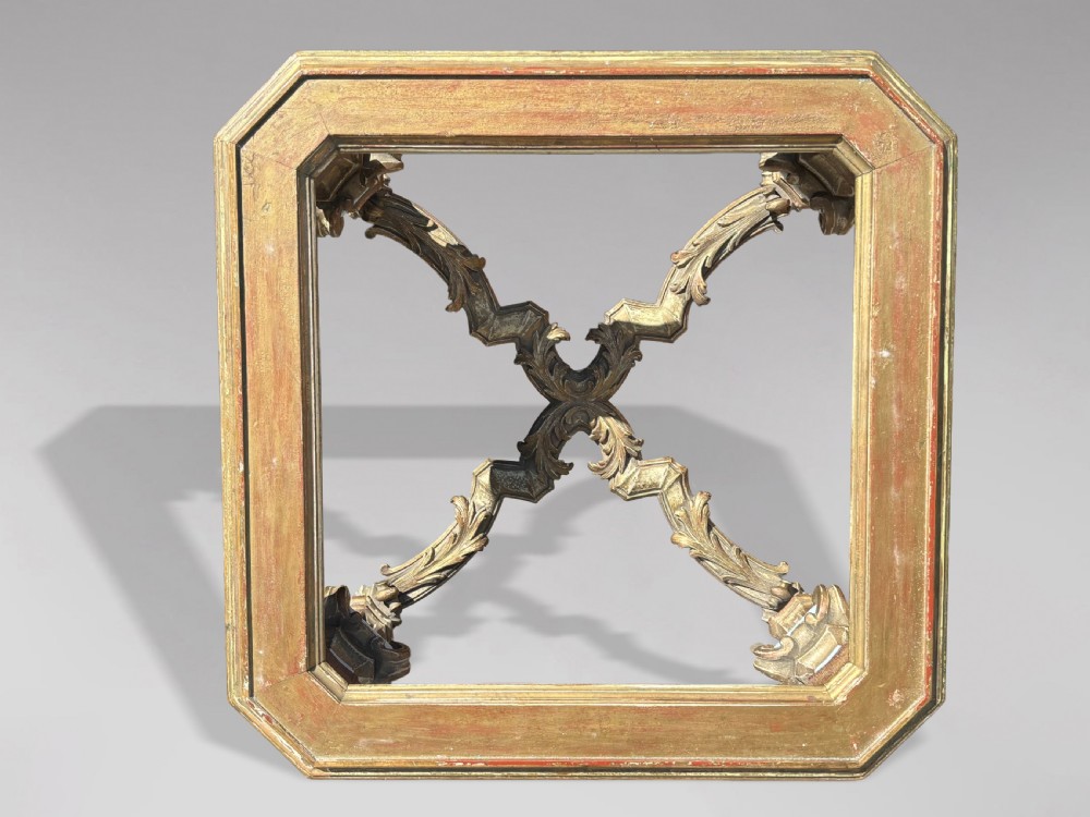 A square Italian Baroque style coffee table featuring a glass top, pale blue paint finish, carved gilt scrollwork frieze, ornate scrolled legs, and an X-shaped stretcher. View VI