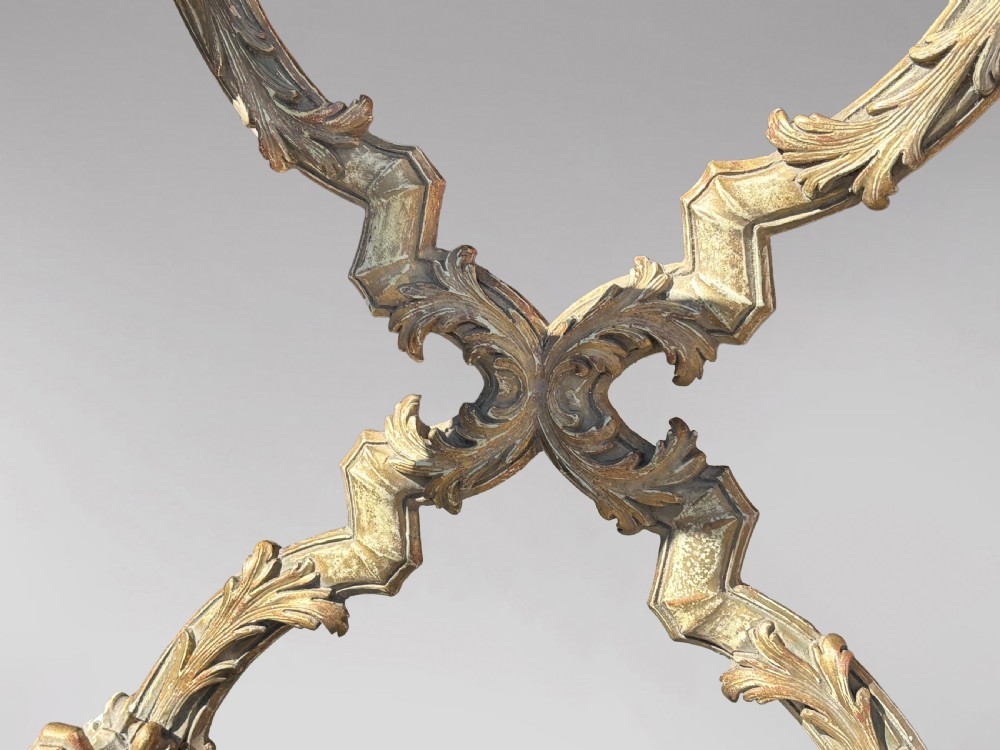 A square Italian Baroque style coffee table featuring a glass top, pale blue paint finish, carved gilt scrollwork frieze, ornate scrolled legs, and an X-shaped stretcher. View VII