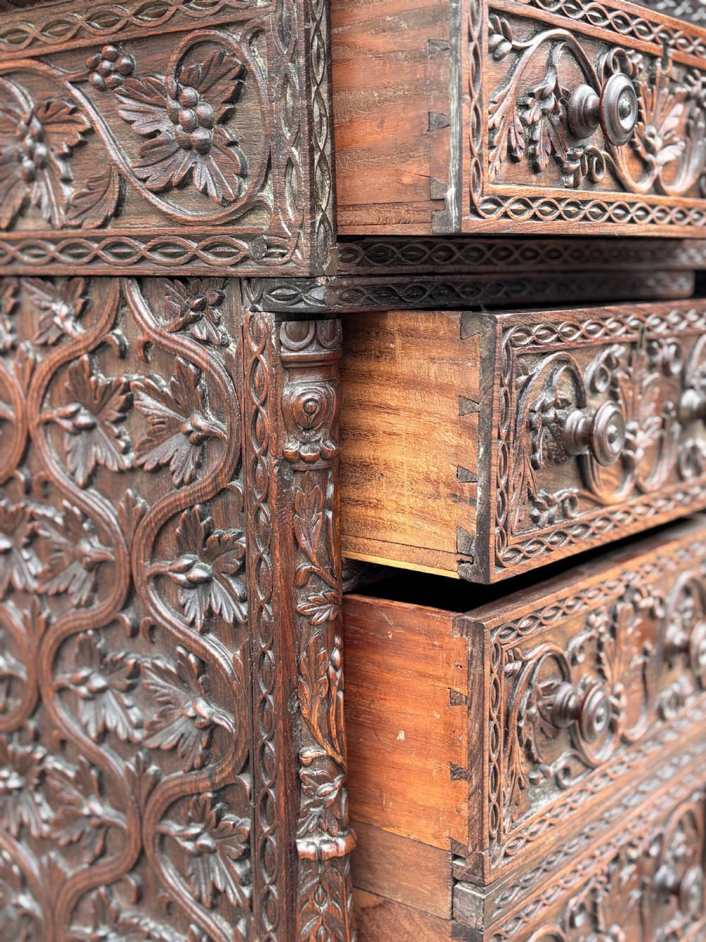 Nineteenth-century Anglo-Indian carved padauk partners desk featuring intricate foliate relief carvings across the pedestal drawers and side panels on turned bun feet. View VI