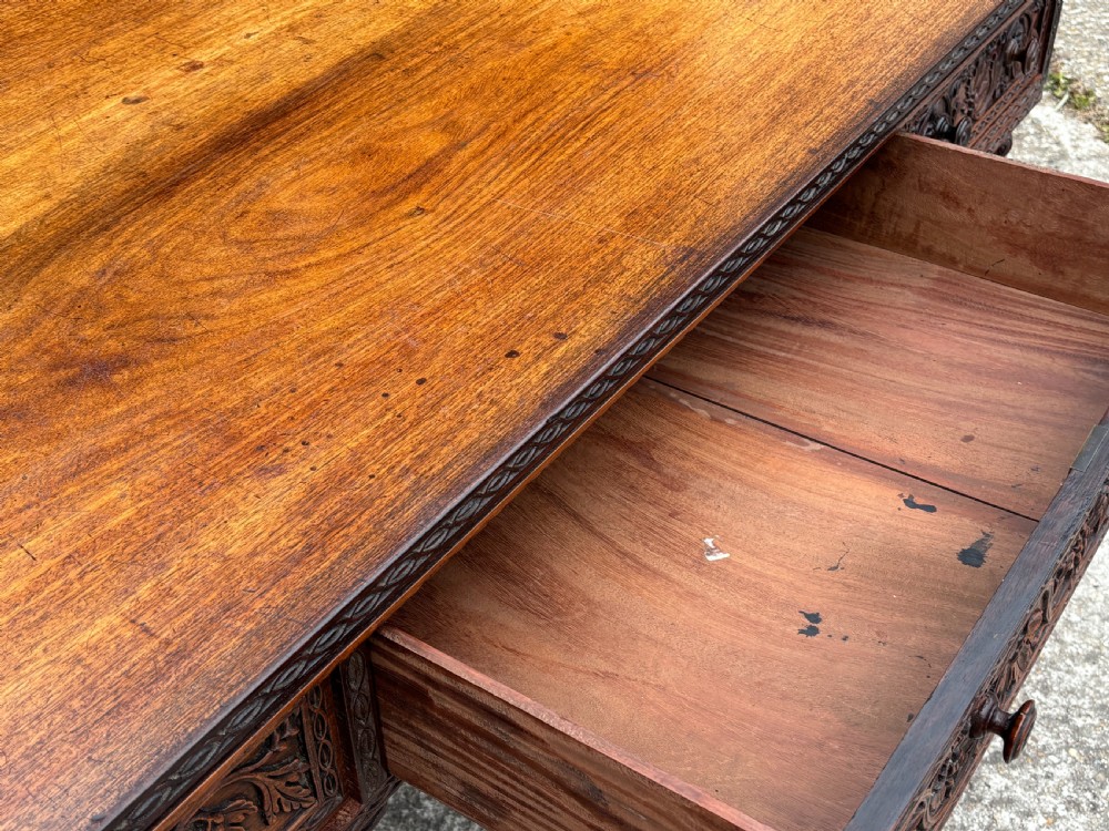 Nineteenth-century Anglo-Indian carved padauk partners desk featuring intricate foliate relief carvings across the pedestal drawers and side panels on turned bun feet. View X