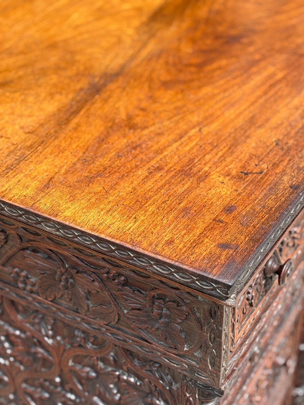 Nineteenth-century Anglo-Indian carved padauk partners desk featuring intricate foliate relief carvings across the pedestal drawers and side panels on turned bun feet. View XI