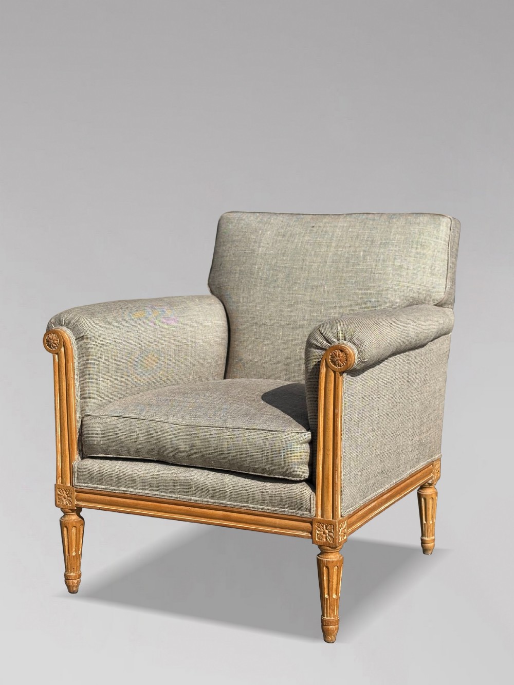 A pair of 19th-century French Louis XVI style armchairs featuring carved wooden frames, fluted legs, and neutral grey woven upholstery. View IV