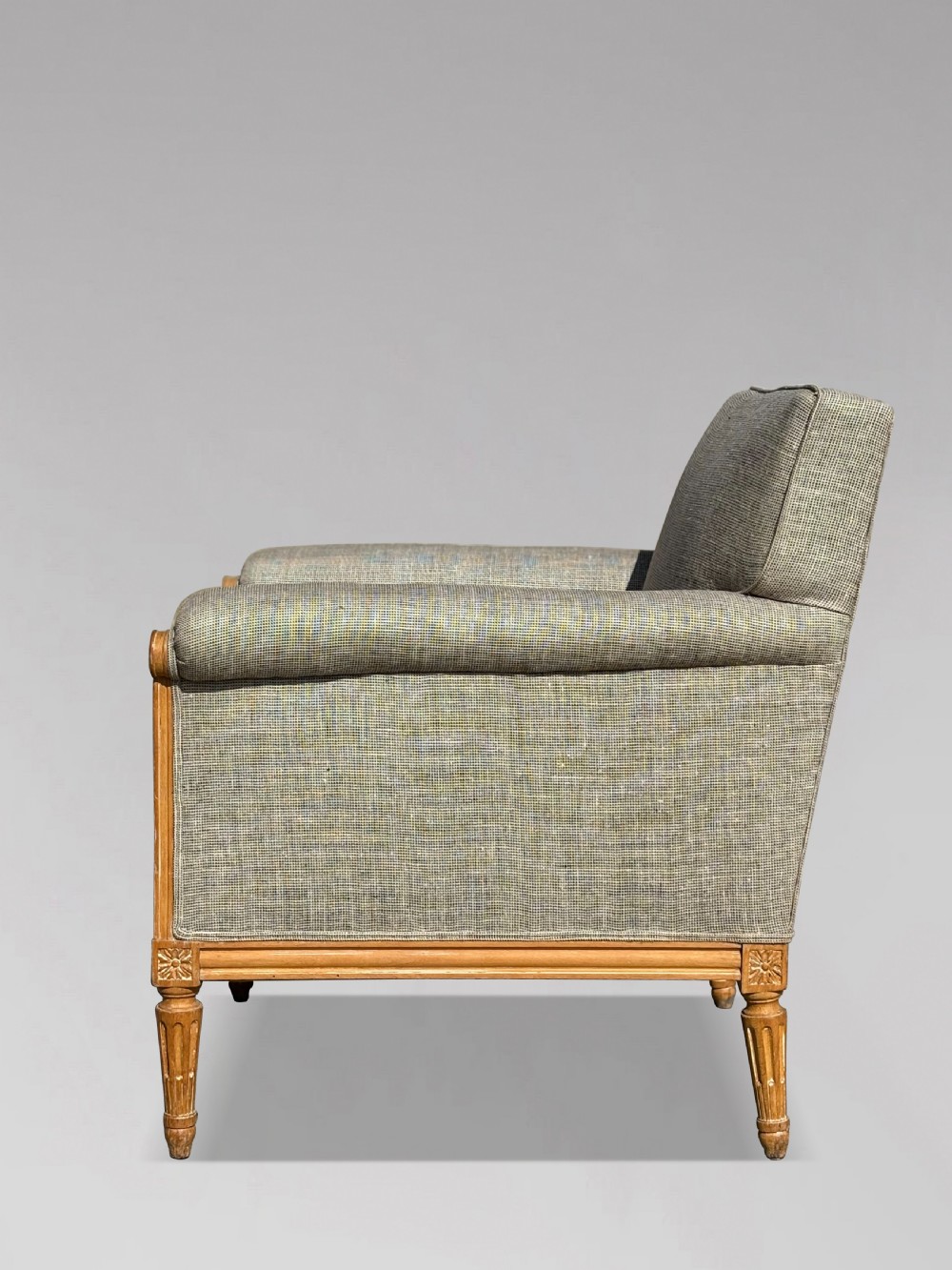 A pair of 19th-century French Louis XVI style armchairs featuring carved wooden frames, fluted legs, and neutral grey woven upholstery. View VI