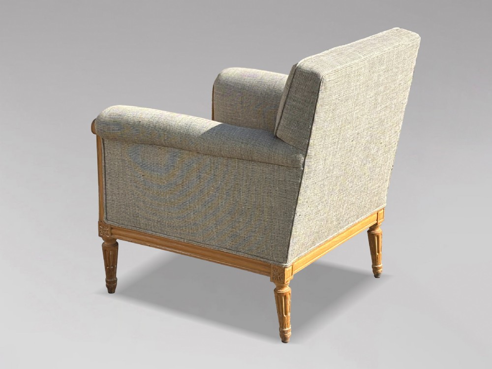 A pair of 19th-century French Louis XVI style armchairs featuring carved wooden frames, fluted legs, and neutral grey woven upholstery. View IX
