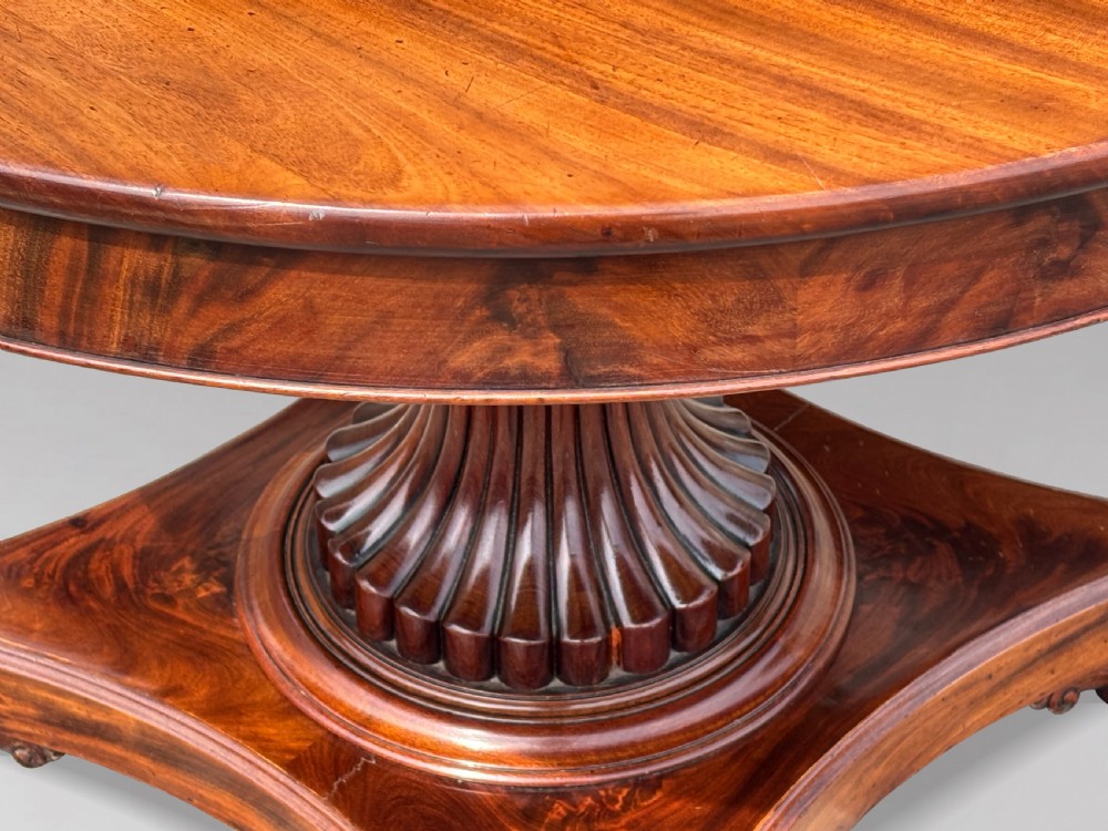 A 19th-century French Charles X mahogany centre table with a circular top, fluted central pedestal, and quadform base on carved feet. View II