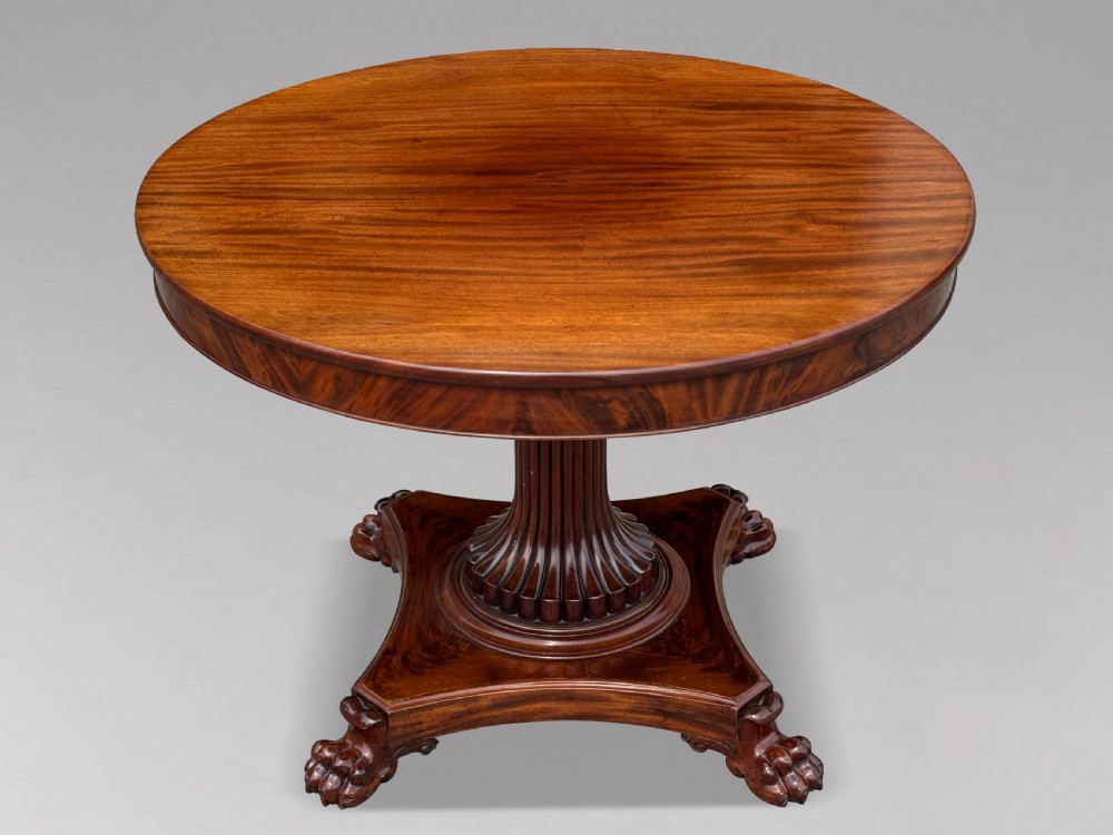 A 19th-century French Charles X mahogany centre table with a circular top, fluted central pedestal, and quadform base on carved feet. View V