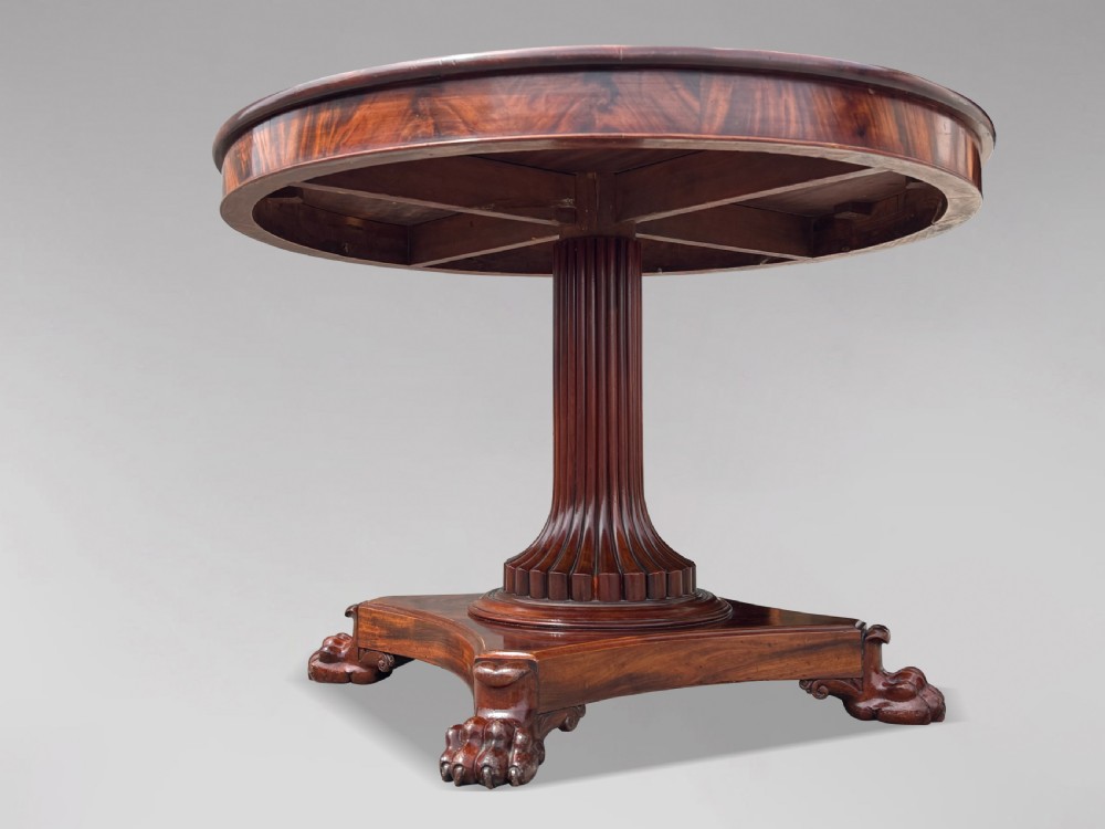 A 19th-century French Charles X mahogany centre table with a circular top, fluted central pedestal, and quadform base on carved feet. View IX