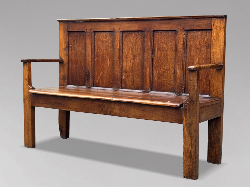An 18th-century Georgian high-back settle crafted from oak and elm featuring a panelled back and wooden armrests. View II