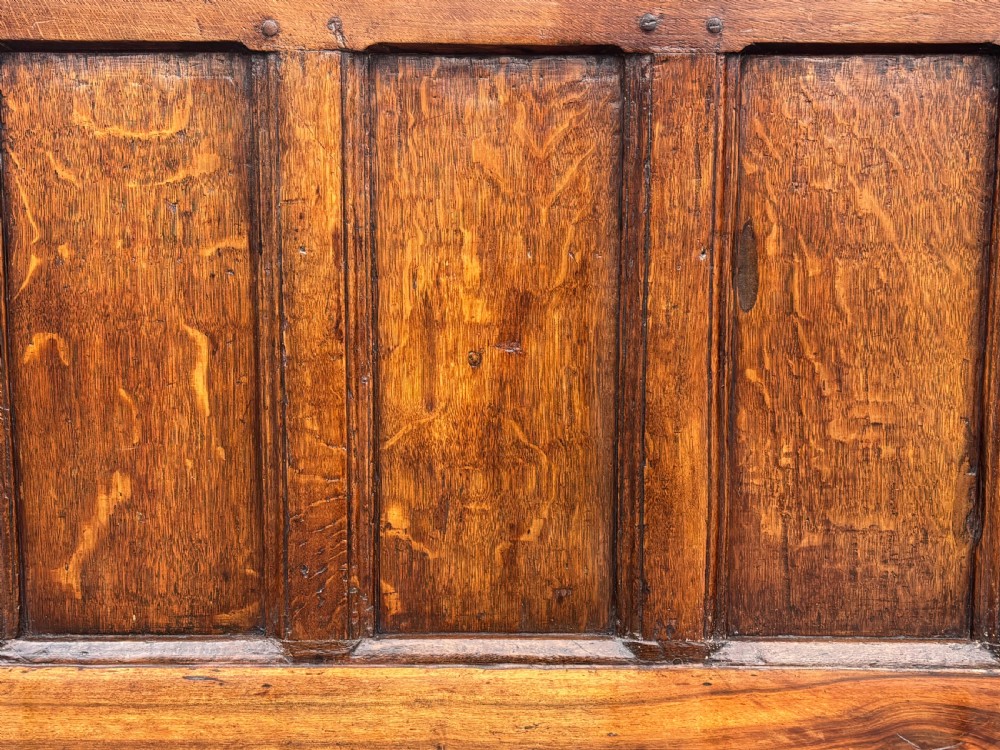 An 18th-century Georgian high-back settle crafted from oak and elm featuring a panelled back and wooden armrests. View IV