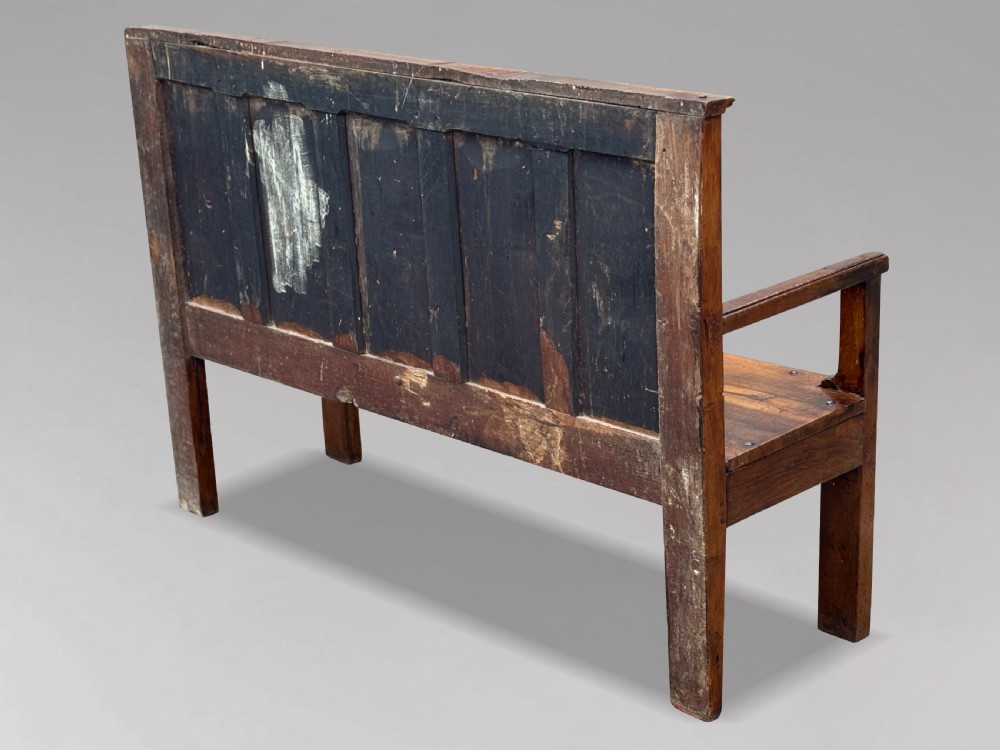 An 18th-century Georgian high-back settle crafted from oak and elm featuring a panelled back and wooden armrests. View VII