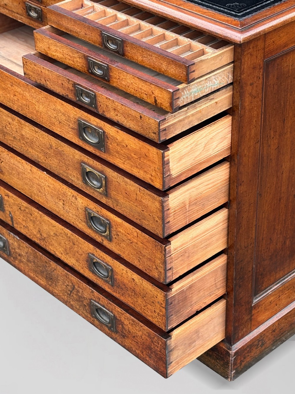 A nineteenth-century mahogany campaign filing cabinet featuring multiple drawers with flush brass handles and a dark leather inset top surface. View VI