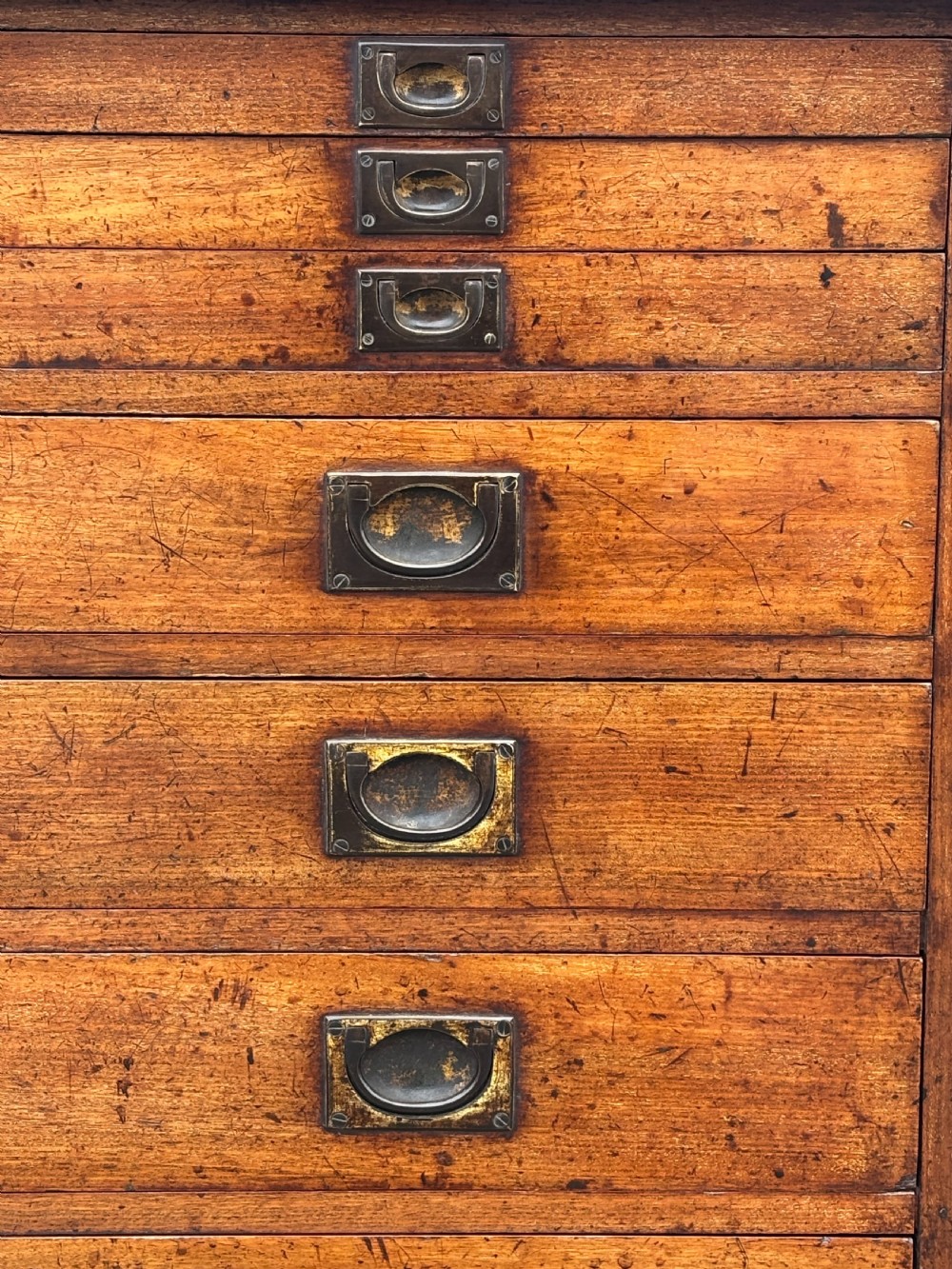 A nineteenth-century mahogany campaign filing cabinet featuring multiple drawers with flush brass handles and a dark leather inset top surface. View IX