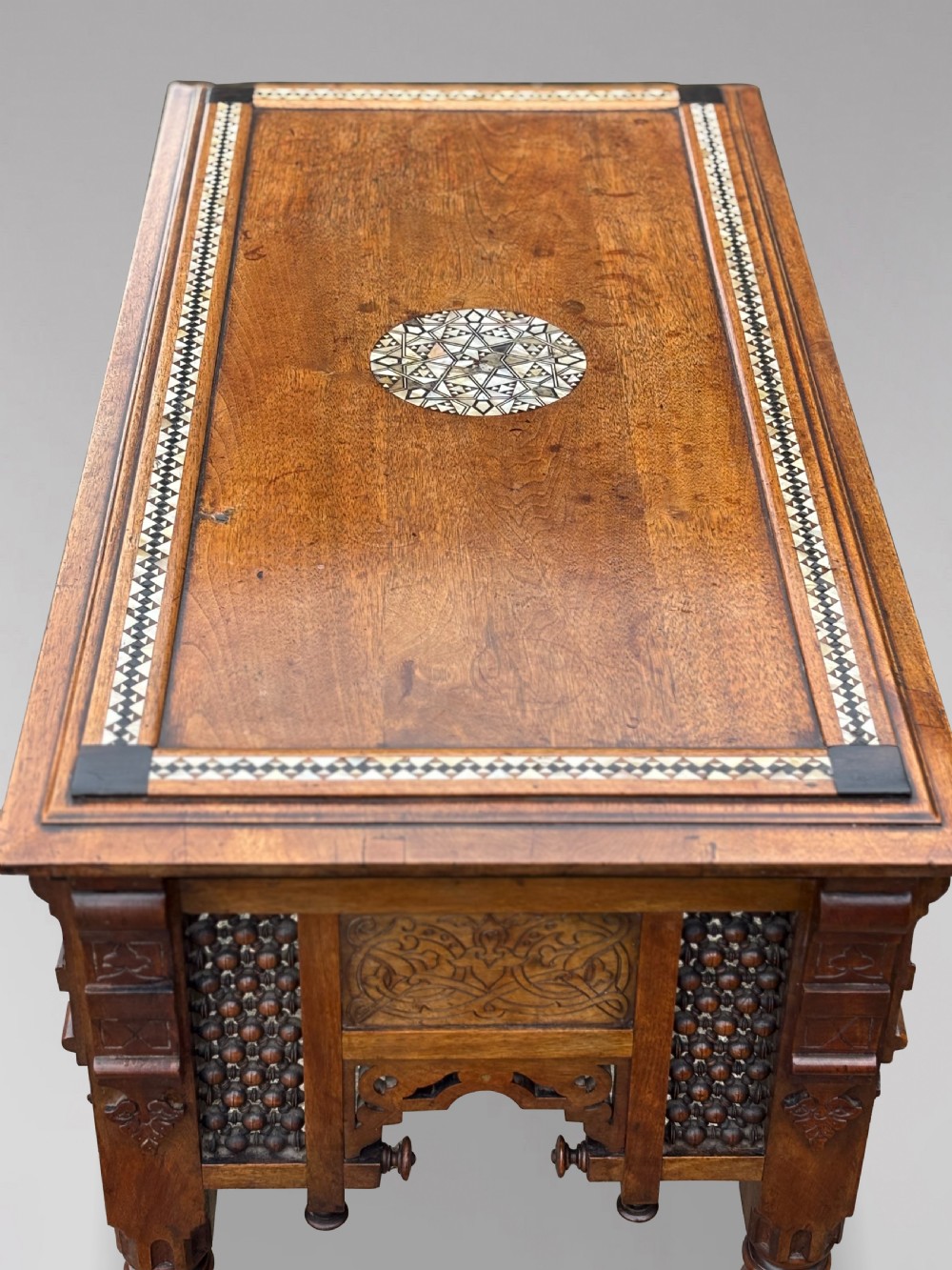A late 19th-century Aesthetic Movement side table featuring carved wood, a central mother-of-pearl inlay medallion, turned spindle side panels, and turned legs. View VII