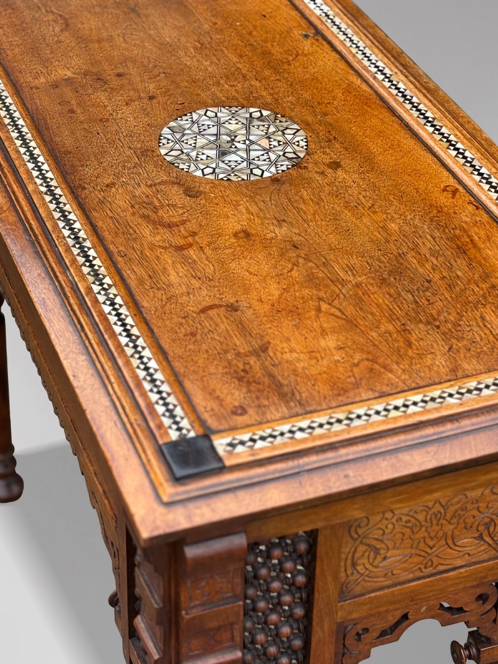 A late 19th-century Aesthetic Movement side table featuring carved wood, a central mother-of-pearl inlay medallion, turned spindle side panels, and turned legs. View VIII
